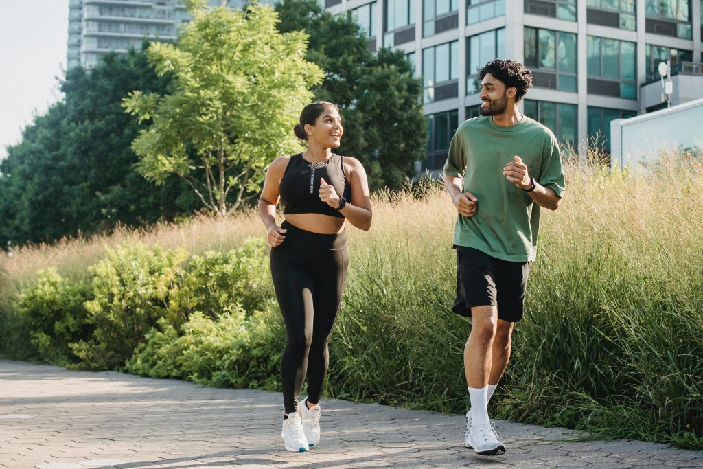 Couple Running down a walkway | Say "Hello" to a Healthy Heart: Three Effortlessly Cool Ways to Keep Your Ticker in Check | Concierge Health and Aesthetics | Sarasota, Florida